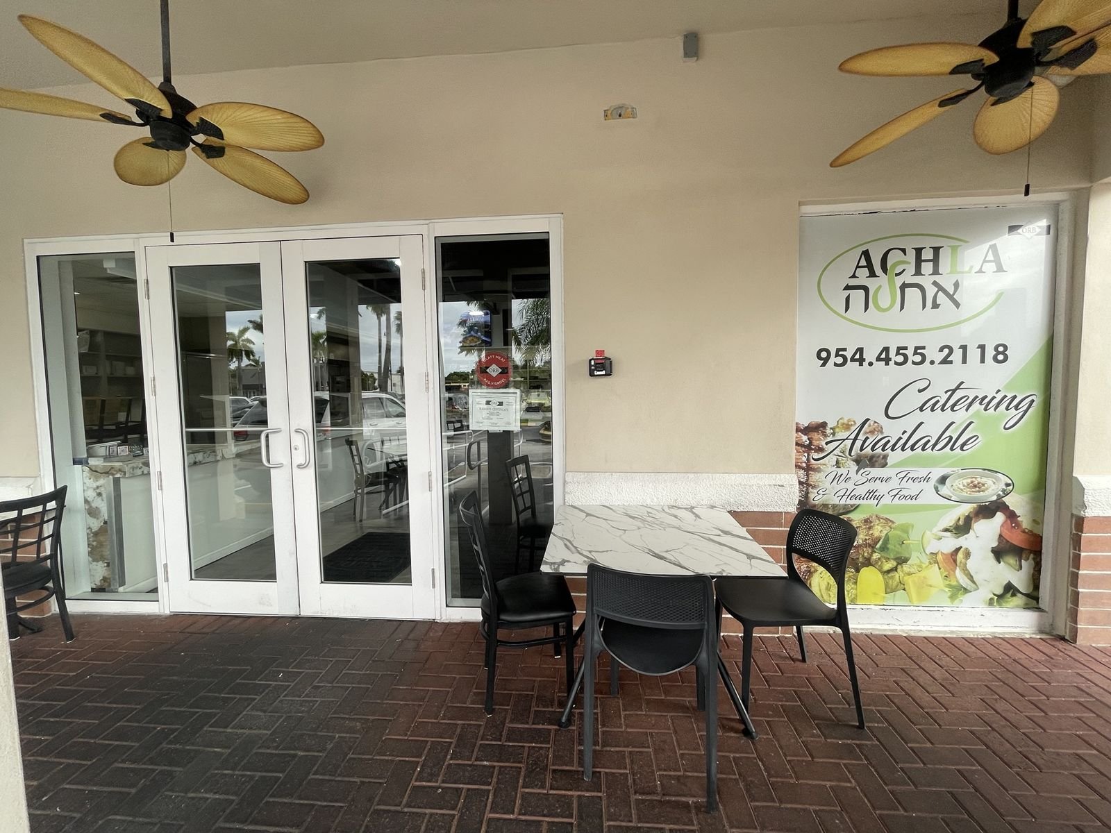 Hummus Achla entrance with ORB kosher certificate and outdoor seating, Hallandale Beach FL