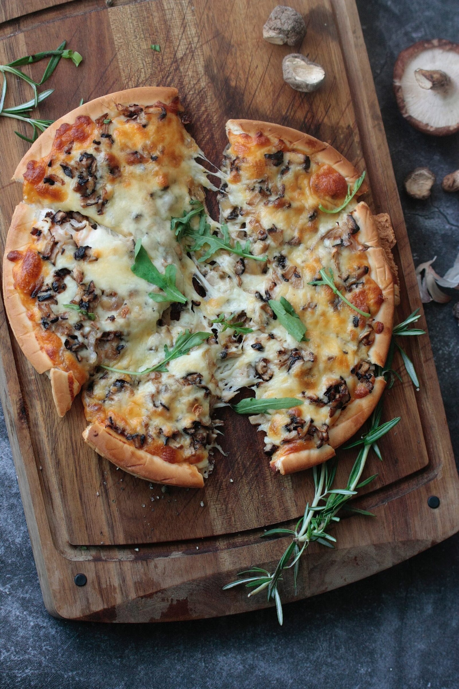 Cheese and mushroom pizza on a wooden board